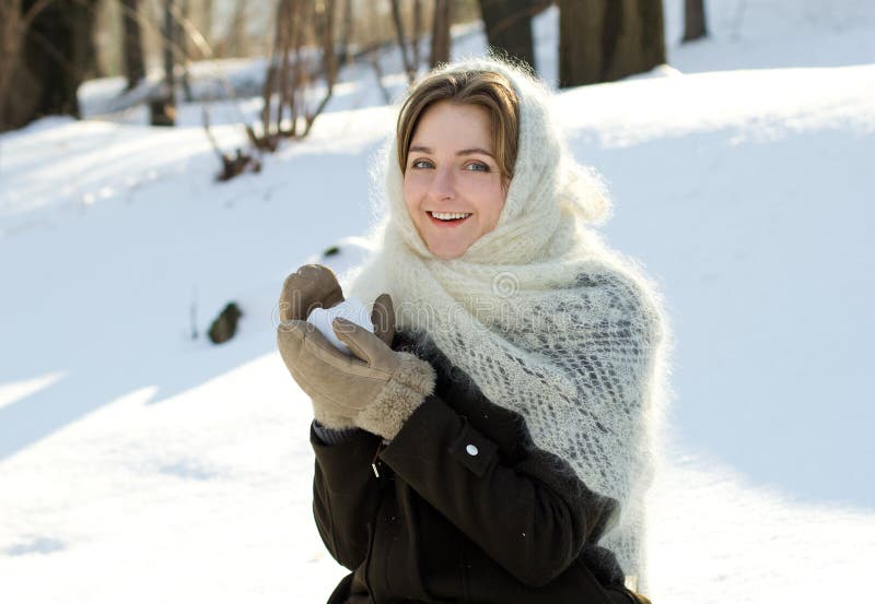 La fille gaie en hiver tricoté d'écharpe jette l'hiver de Russe de neige photographie stock libre de droits La fille gaie en hiver tricoté d'écharpe jette l'hiver de Russe de neige photographie stock libre de droits