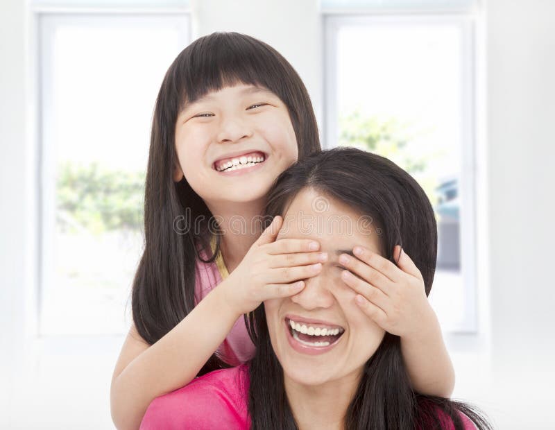 La fille heureuse couvrent ses yeux de mère photographie stock La fille heureuse couvrent ses yeux de mère photographie stock