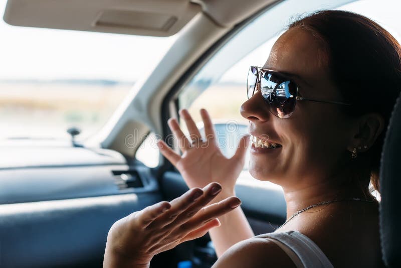 La fille heureuse en verres sur le siège de passager dans la voiture rit photos libres de droits La fille heureuse en verres sur le siège de passager dans la voiture rit photos libres de droits