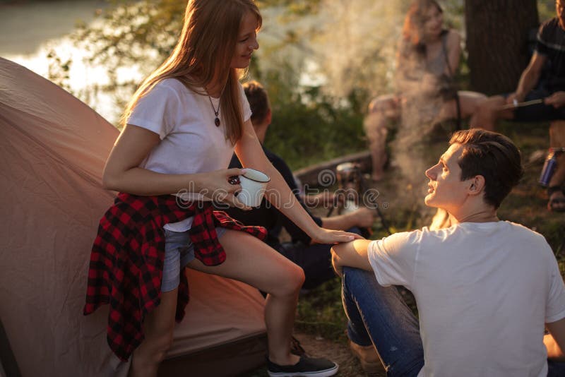 La fille impressionnante de gingembre flirte avec le garçon beau faihaired au terrain de camping photographie stock libre de droits