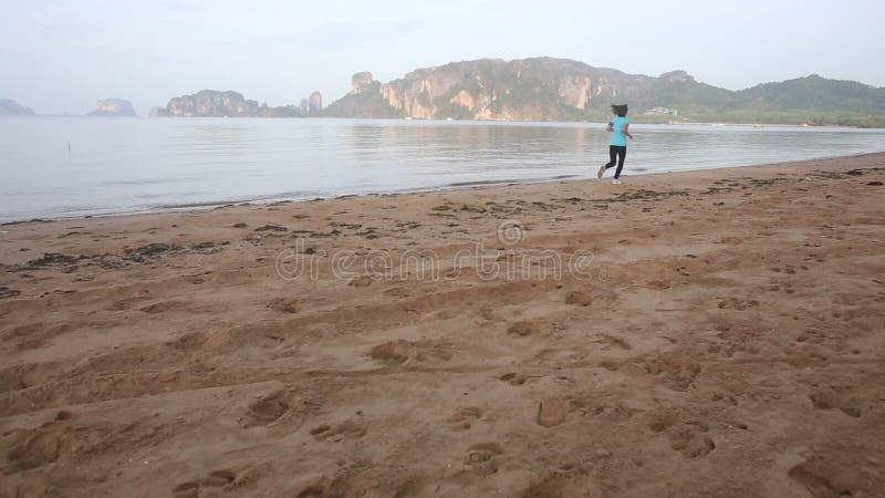 la fille marche et commence à courir le long de la plage