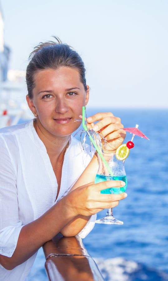 La fille mignonne avec un cocktail froid, apprécient le reste de la croisière photos stock La fille mignonne avec un cocktail froid, apprécient le reste de la croisière photos stock