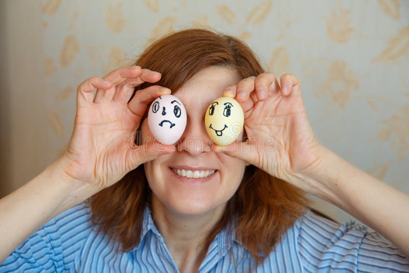La fille montre les oeufs peints pour Pâques avec les visages drôles images stock La fille montre les oeufs peints pour Pâques avec les visages drôles images stock