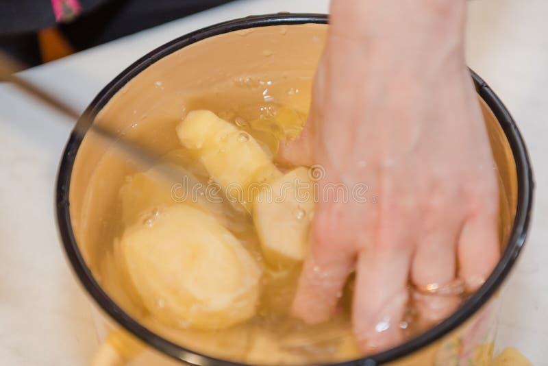 La fille nettoie les pommes de terre Cuisson à la maison Produits naturels Cuisson d'un plat des pommes de terre photo stock La fille nettoie les pommes de terre Cuisson à la maison Produits naturels Cuisson d'un plat des pommes de terre photo stock
