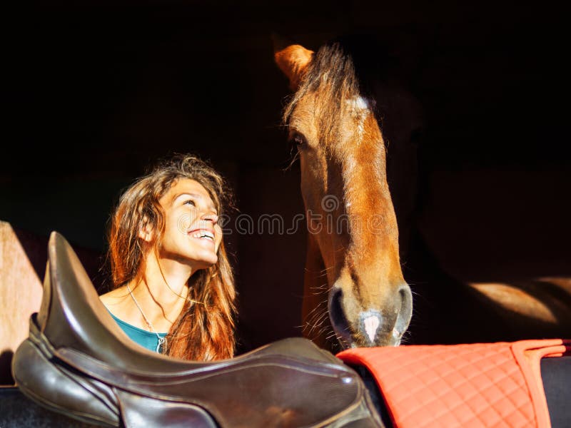 La fille regarde la tête d'un cheval rouge avec amour photo libre de droits La fille regarde la tête d'un cheval rouge avec amour photo libre de droits
