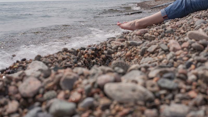 La fille s'assied sur le rivage de Baikal