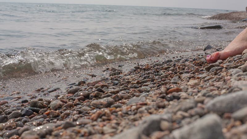 La fille s'assied sur le rivage de Baikal