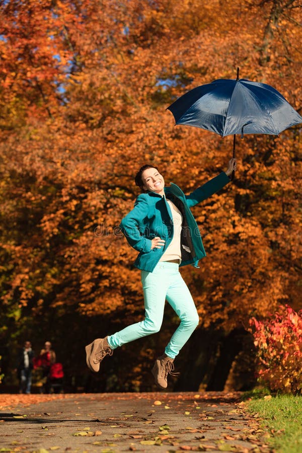 Download La Fille Sautant Avec Le Parapluie Bleu En Parc Automnal Photo stock - Image du apprécier, jeune: 45361628