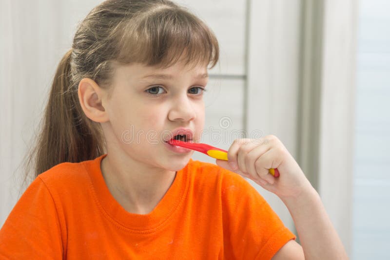 La fille se brosse les dents dans la salle de bains photo libre de droits La fille se brosse les dents dans la salle de bains photo libre de droits