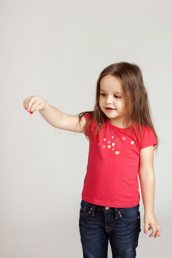 La fille tient quelque chose de sa main images stock La fille tient quelque chose de sa main images stock