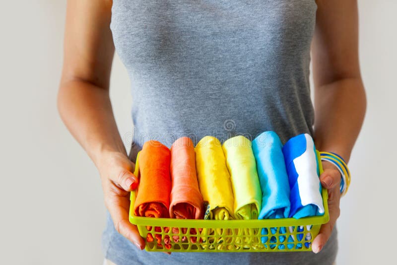 La fille tient un panier avec les vêtements pliés Conservation des choses photographie stock La fille tient un panier avec les vêtements pliés Conservation des choses photographie stock