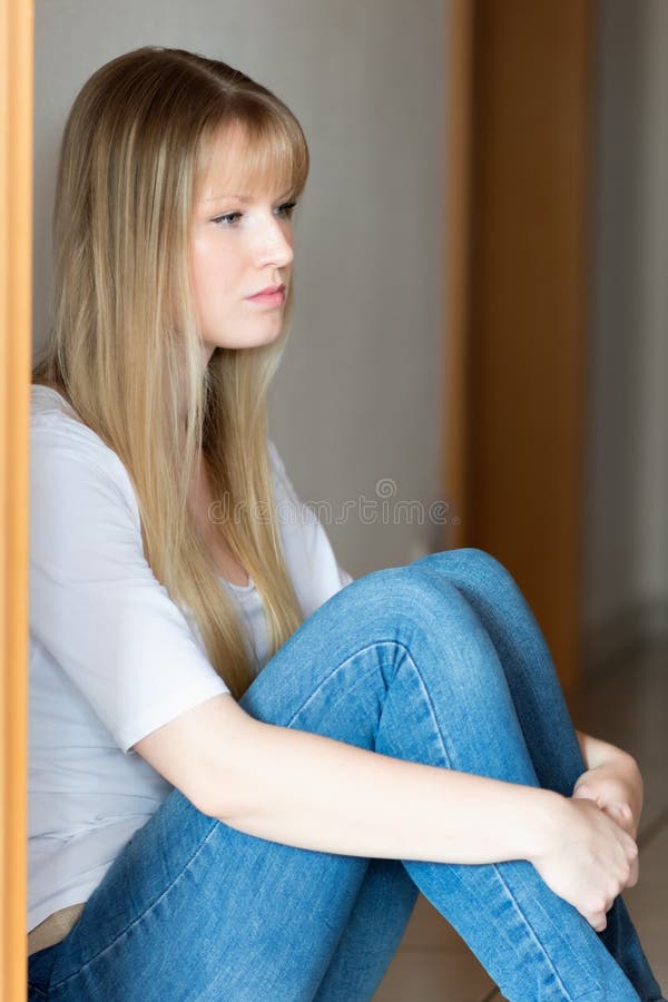 La fille triste s'assied sur l'étage photos libres de droits La fille triste s'assied sur l'étage photos libres de droits