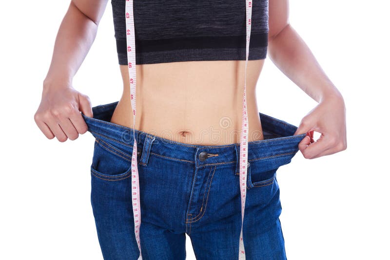 La fin vers le haut de la femme de perte de poids utilisant ses vieux jeans et la mesure tapent images libres de droits La fin vers le haut de la femme de perte de poids utilisant ses vieux jeans et la mesure tapent images libres de droits