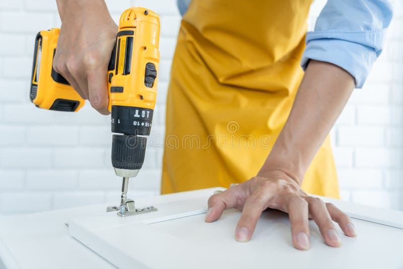 homme utilisant un tournevis sans fil assemblant des meubles à la maison,  charpentier travaillant avec un tournevis électrique sur le travail  25498776 Photo de stock chez Vecteezy