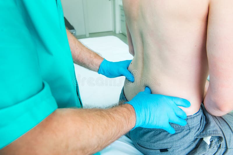 La fin vers le haut du docteur masculin de neurologue diagnostique la colonne lombaire du patient masculin dans la clinique m?dic image libre de droits La fin vers le haut du docteur masculin de neurologue diagnostique la colonne lombaire du patient masculin dans la clinique m?dic image libre de droits