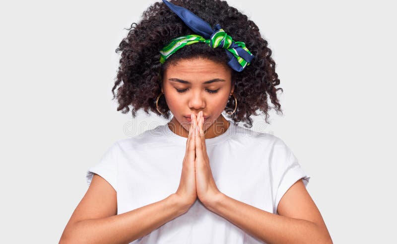 La fine orizzontale sull'immagine di giovane donna di afro tiene le mani nel pregare il gesto fotografia stock La fine orizzontale sull'immagine di giovane donna di afro tiene le mani nel pregare il gesto fotografia stock