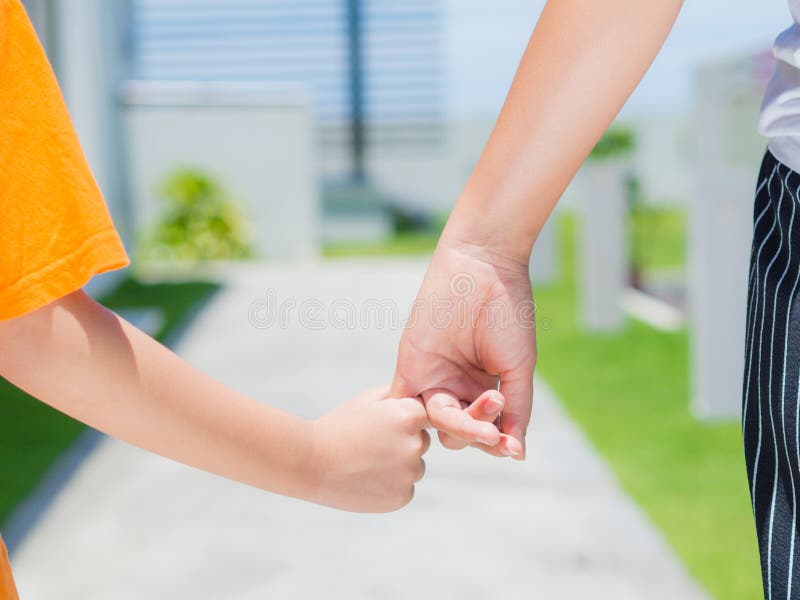 La fine su della donna tiene la mano di un bambino adorabile fotografia stock libera da diritti La fine su della donna tiene la mano di un bambino adorabile fotografia stock libera da diritti
