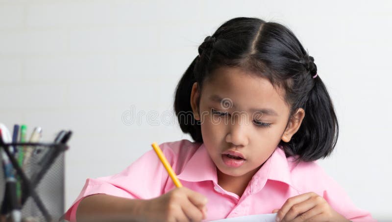 La fine sulla bambina sta facendo intento il compito immagini stock libere da diritti La fine sulla bambina sta facendo intento il compito immagini stock libere da diritti