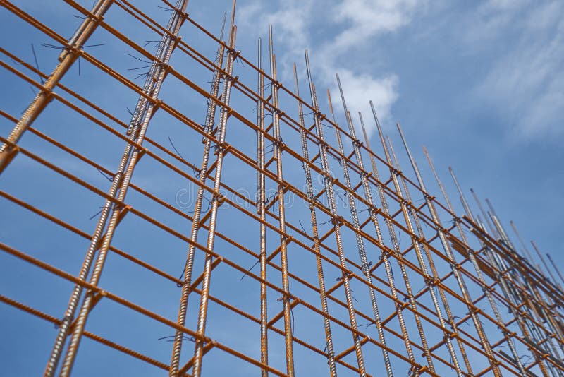 La forma d'acciaio della barra e del legname di rinforzo funziona al cantiere sul fondo del cielo blu immagine stock La forma d'acciaio della barra e del legname di rinforzo funziona al cantiere sul fondo del cielo blu immagine stock