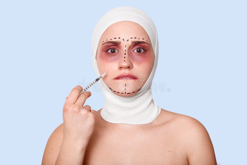 La foto della donna battuta triste tiene la siringa con il siero, ha cattivo umore, aspetta le procedure della chirurgia Ragazze immagini stock La foto della donna battuta triste tiene la siringa con il siero, ha cattivo umore, aspetta le procedure della chirurgia Ragazze immagini stock