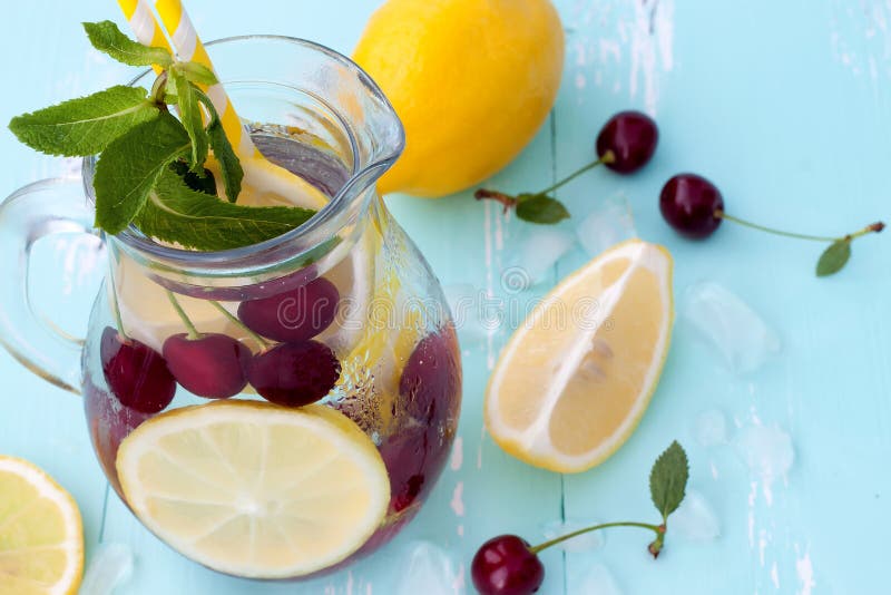 La frutta della disintossicazione ha infuso l'acqua condita con la ciliegia, il limone e la menta fotografie stock La frutta della disintossicazione ha infuso l'acqua condita con la ciliegia, il limone e la menta fotografie stock