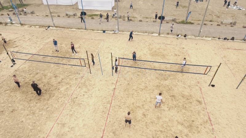 La gente aerea del colpo che gioca il valleyball ed il volano della spiaggia sulla sabbia ha abbracciato il campo