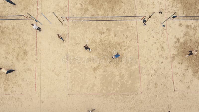 La gente aerea del colpo gioca a calcio, volano e pallavolo al campo sportivo della sabbia