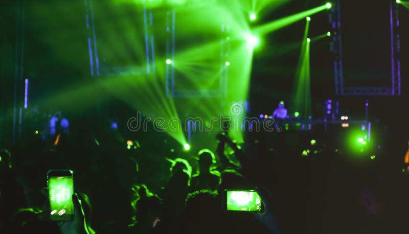 Blurred people dancing at music night festival event - Abtsract defocused image background of disco club after party with laser show - Nightlife entertainment concept. Blurred people dancing at music night festival event - Abtsract defocused image background of disco club after party with laser show - Nightlife entertainment concept