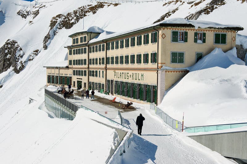 La gente camina por la terraza del hotel de lujo de Pilatus-Kulm en la cima de la montaña de Pilatus en Lucern, Suiza fotografía de archivo La gente camina por la terraza del hotel de lujo de Pilatus-Kulm en la cima de la montaña de Pilatus en Lucern, Suiza fotografía de archivo