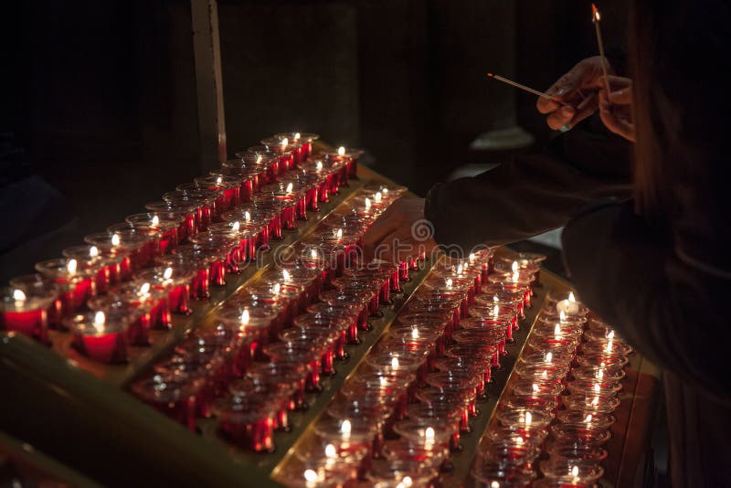 La gente che accende le candele nella cattedrale di Notre Dame a Parigi, Francia La bruciatura della candela è una pratica abitua