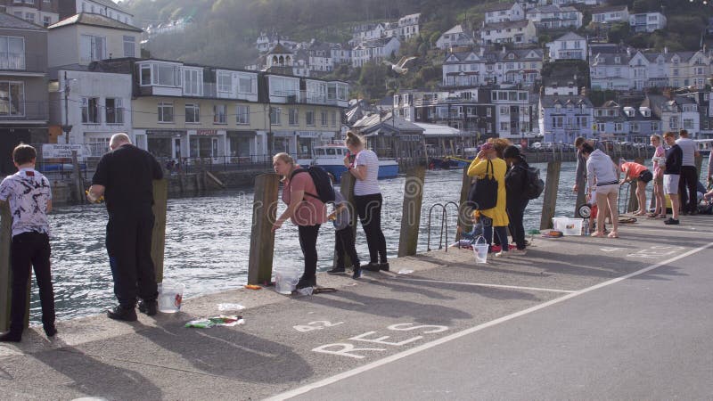 La gente che gode di una certa pesca del granchio dal porto Looe orientale, Cornovaglia, Regno Unito immagini stock libere da diritti La gente che gode di una certa pesca del granchio dal porto Looe orientale, Cornovaglia, Regno Unito immagini stock libere da diritti