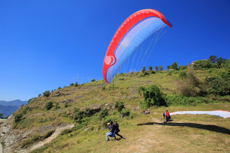 La gente che guarda il volo di parapendio contro il cielo blu immagini stock libere da diritti La gente che guarda il volo di parapendio contro il cielo blu immagini stock libere da diritti