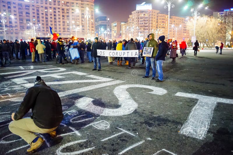 La gente che scrive messaggio sul calcestruzzo alla protesta, Bucarest, Romania immagine stock libera da diritti La gente che scrive messaggio sul calcestruzzo alla protesta, Bucarest, Romania immagine stock libera da diritti