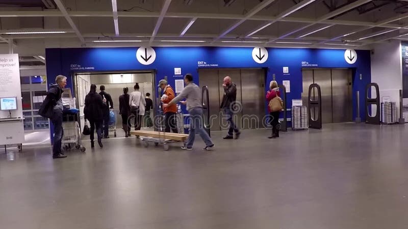 La gente che spinge la loro mobilia sul carrello verso l'elevatore