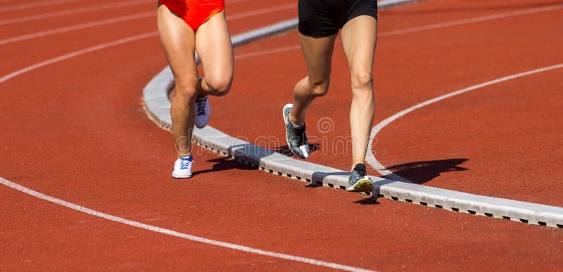 La gente di atletica che corre sul campo della pista Giorno pieno di sole immagini stock libere da diritti La gente di atletica che corre sul campo della pista Giorno pieno di sole immagini stock libere da diritti