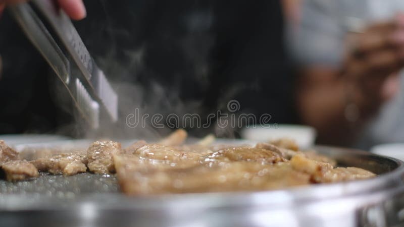 La gente disfruta de la parrilla y come filetes juntos