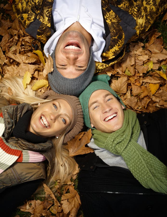 La gente felice in autunno parcheggia la stenditura fra i fogli immagine stock La gente felice in autunno parcheggia la stenditura fra i fogli immagine stock