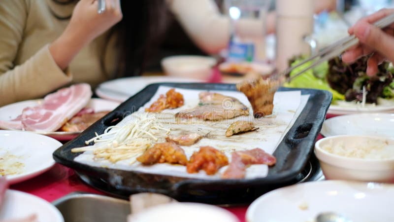 La gente goza de las comidas asadas a la parrilla y come en el restaurante