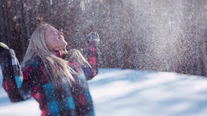 La gente joven feliz en un invierno colorido lleva lanzar para arriba la nieve en una sol brillante Memorias de la niñez Invierno