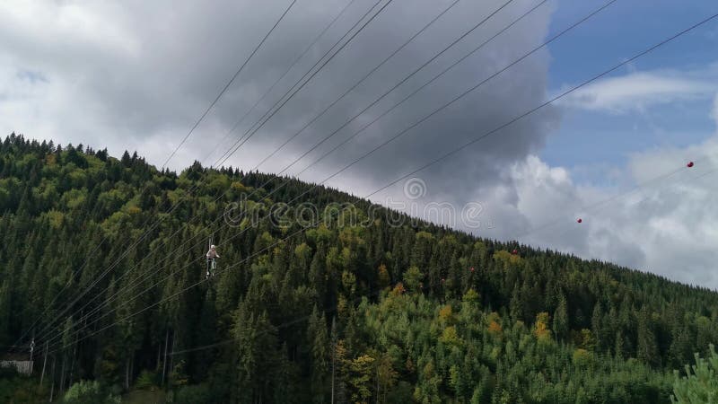 La gente monta bicicletas en los cables sobre el lago. un tipo de atracción de la ziplina