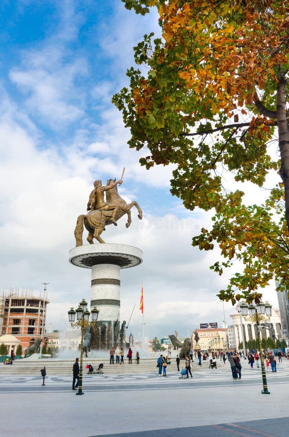 La gente no identificada camina a través del cuadrado de Macedonia debajo del guerrero en un monumento del caballo de Skopje imágenes de archivo libres de regalías La gente no identificada camina a través del cuadrado de Macedonia debajo del guerrero en un monumento del caballo de Skopje imágenes de archivo libres de regalías