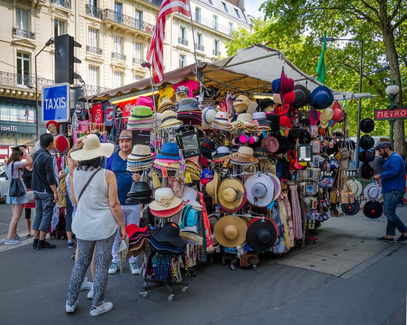 La gente prova sopra i cappelli ad un supporto di ricordo a Parigi fotografie stock libere da diritti La gente prova sopra i cappelli ad un supporto di ricordo a Parigi fotografie stock libere da diritti
