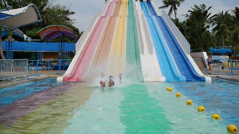 La gente se divierte que resbala abajo en Aquapark