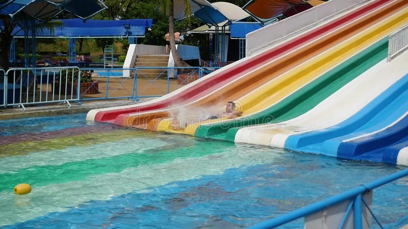 La gente se divierte que resbala abajo en Aquapark