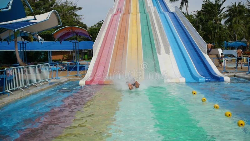 La gente se divierte que resbala abajo en Aquapark