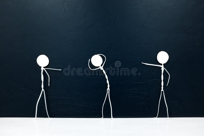 People figures pointing fingers on a scared stick man on a dark background. Bullying, victim blaming, accusation and abuse concept. Black background. People figures pointing fingers on a scared stick man on a dark background. Bullying, victim blaming, accusation and abuse concept. Black background.