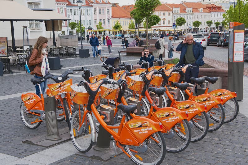 La gente sta al punto locativo della bicicletta al quadrato del comune a Vilnius, Lituania fotografie stock libere da diritti