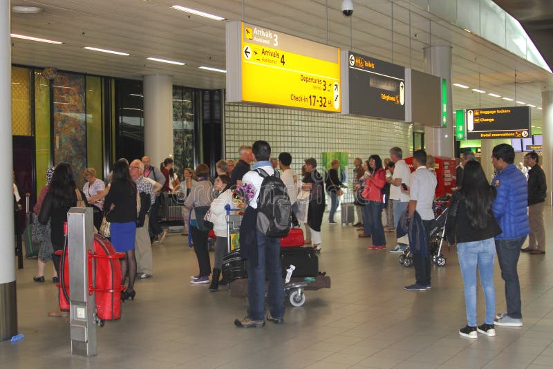 La gente sta aspettando nel corridoio di arrivo all'aeroporto di Schiphol fotografia stock libera da diritti La gente sta aspettando nel corridoio di arrivo all'aeroporto di Schiphol fotografia stock libera da diritti