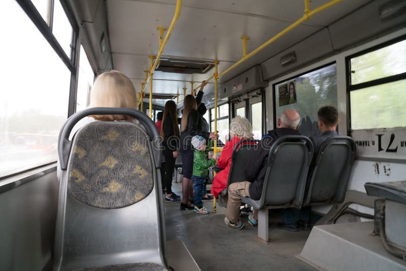 La gente sta e si siede dentro la cabina di un bus pubblico fotografia stock