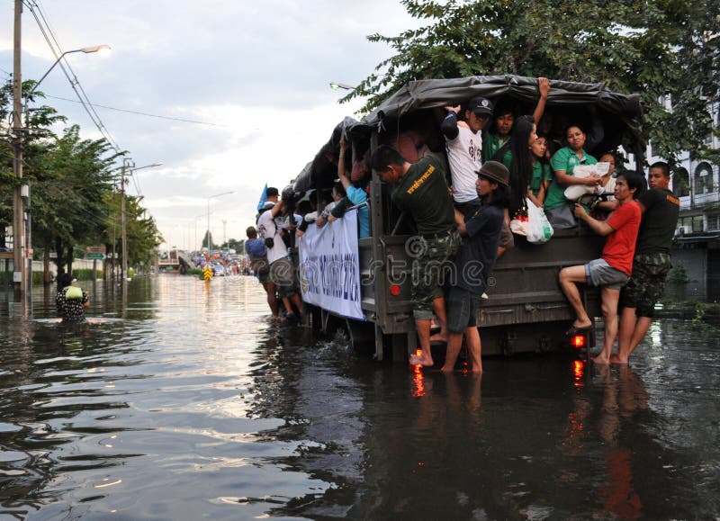 La gente sta permutando in un camion di esercito in una via sommersa a Bangkok, Tailandia, nell'ottobre 2011 immagini stock La gente sta permutando in un camion di esercito in una via sommersa a Bangkok, Tailandia, nell'ottobre 2011 immagini stock